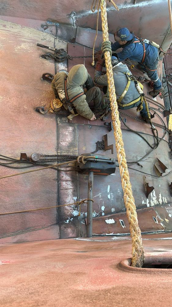 Cuadrilla de Master Ships trabajando sobre el casco con arnés de seguridad